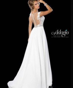 Woman in a sleeveless white bridal gown with sheer back and floral applique detailing, posing against a black background.