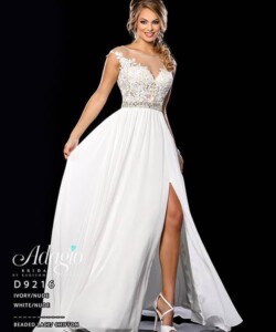 Woman wearing an ivory lace and chiffon evening gown with a sheer bodice and a high leg slit.